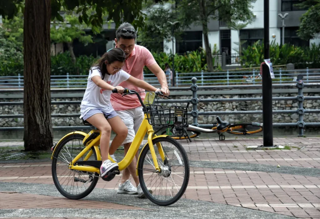 Pai ensinando a filha a andar de bicicleta