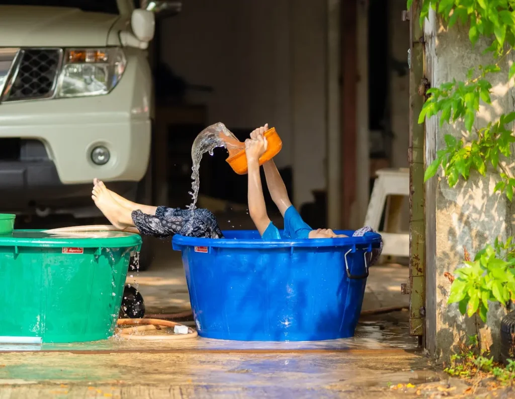 Criança tomando banho de bacia