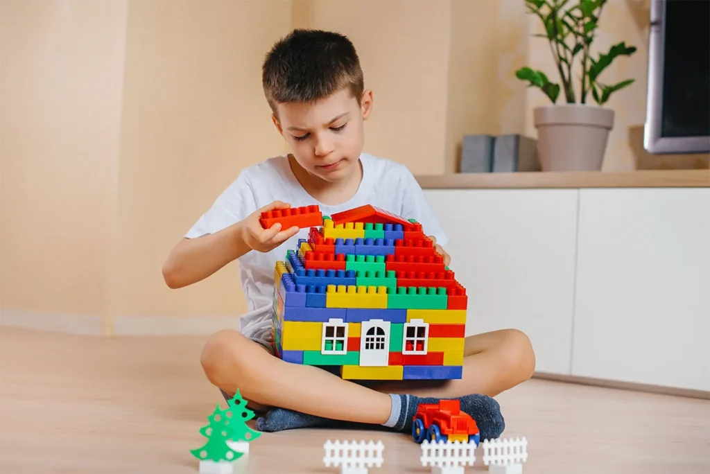 Menino de 5 anos brincando com lego