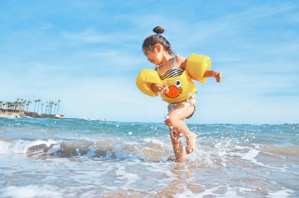 Menina de 4 anos se divertindo na praia