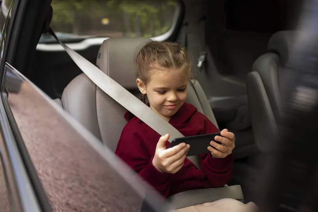 Criança viajando no carro assistindo ao celular