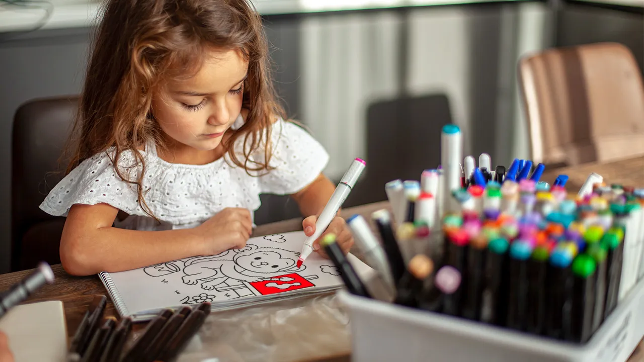 Menina de 4 anos colorindo o Livro de Colorir PDF 'Mundo dos Bichinhos' para crianças – atividade educativa com desenhos de animais para imprimir.